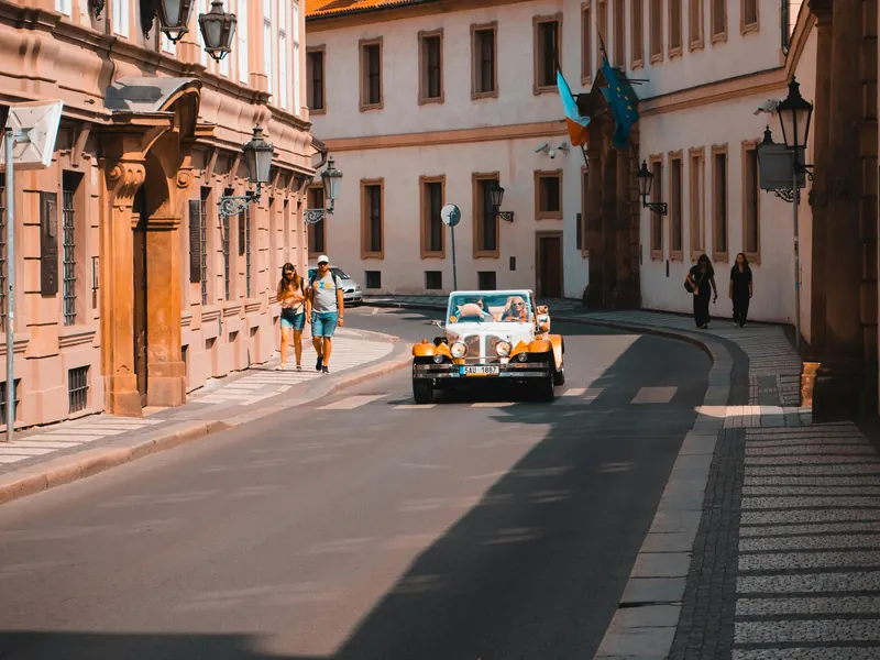 White vintage cabrio rolling down a Prague palace street