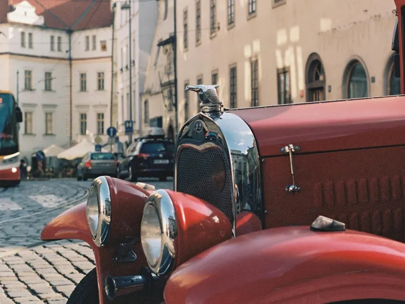 Polished red vintage car bonnet detail in a Prague square