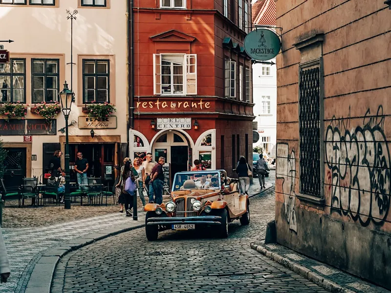 Bronze vintage cabrio parked outside a Prague restaurant
